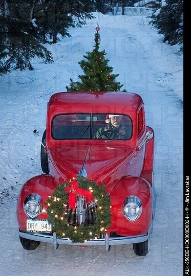 Ford 1938 com guirlanda de Natal presa na dianteira e árvore de Natal ma traseira 