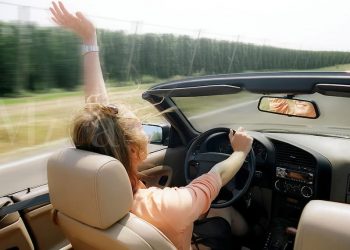 Woman driving convertible through the countryside.
MR