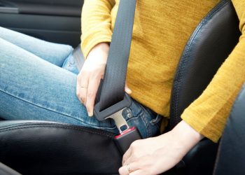 woman hand fastening a seat belt in the car